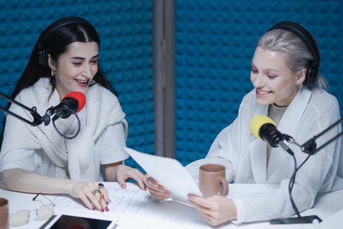 Two women looking over podcast intro script ahead of show