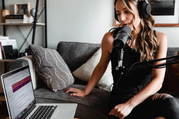 Young woman recording a podcast in her living room