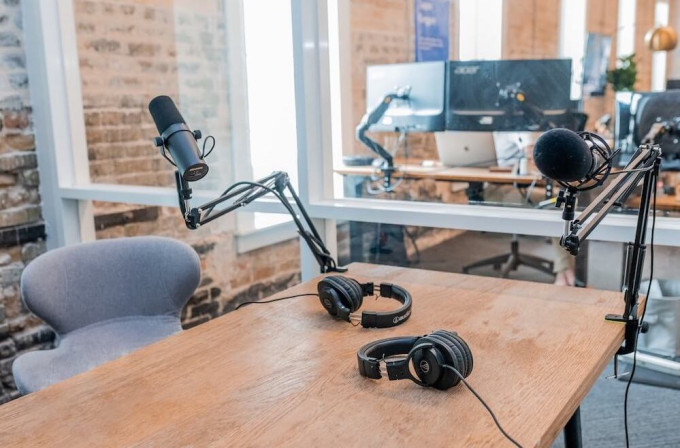 Desk with podcast microphones and headphones on it
