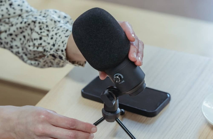 Hands tilting microphone into position