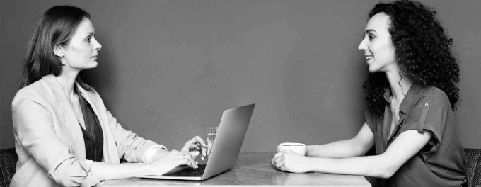 Woman with a laptop interviewing a second woman