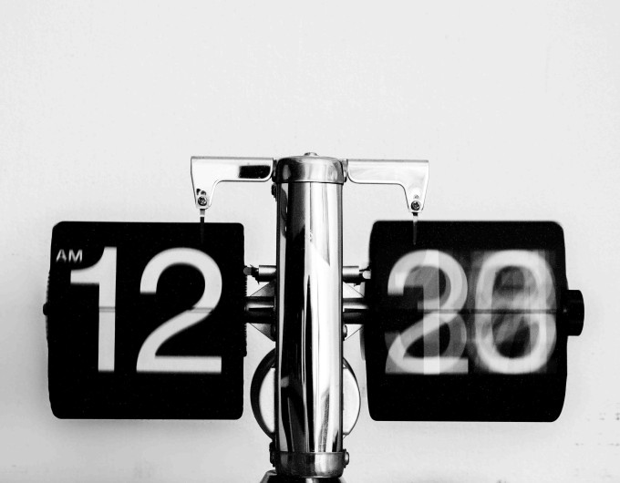 Grayscale image of a digital clock, highlighting the importance of effective time management when learning how to plan a podcast