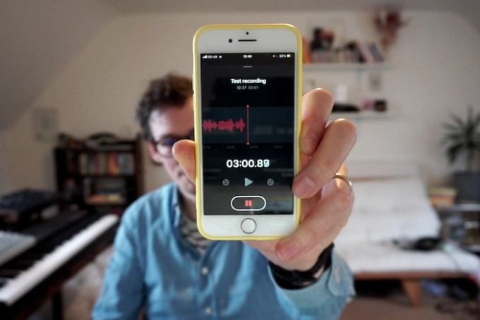 Image of a hand holding up a voice memo app on a smartphone