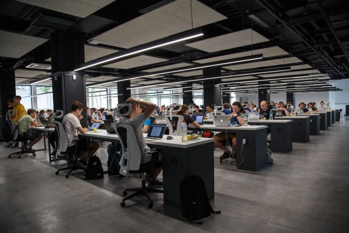 Large open plan office filled with workers at laptops