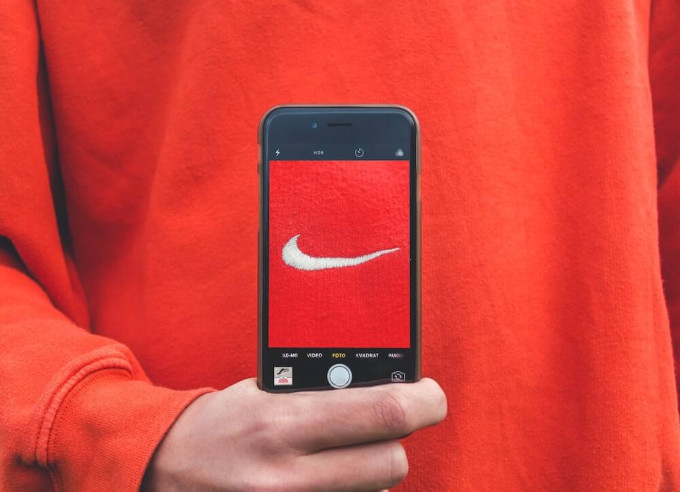 Person holding smartphone with Nike logo on screen