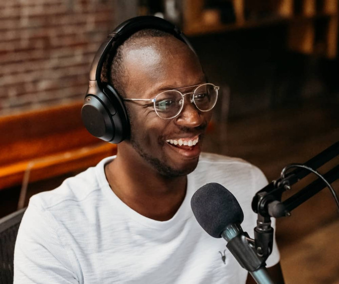 Smiling man wearing headphones and recording a podcast