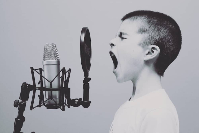 Young boy shouting into microphone, not the best mic technique