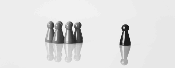 Graphic of Chess pawn pieces, with one standing apart from the group