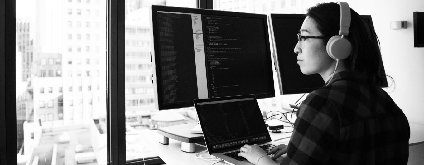 Person at a computer, overlooking a city view from the office window