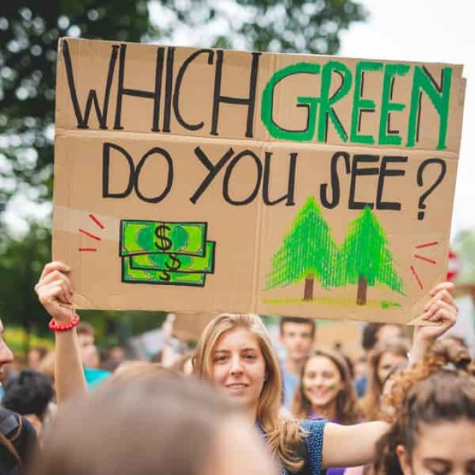 Woman holding a sign to symbolize the environmental benefits of remote work