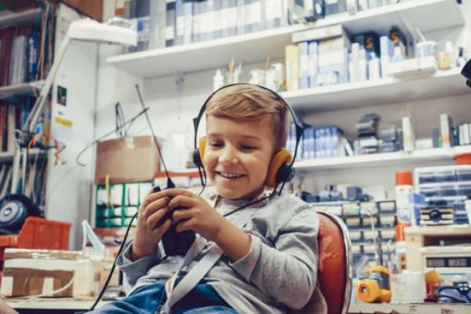 A young boy smiling with headphones on