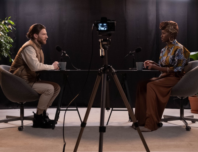 Podcast interview with hipster guy and African woman in traditional dress