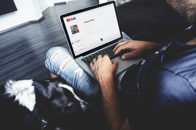 Man at laptop adding podcast details to YouTube